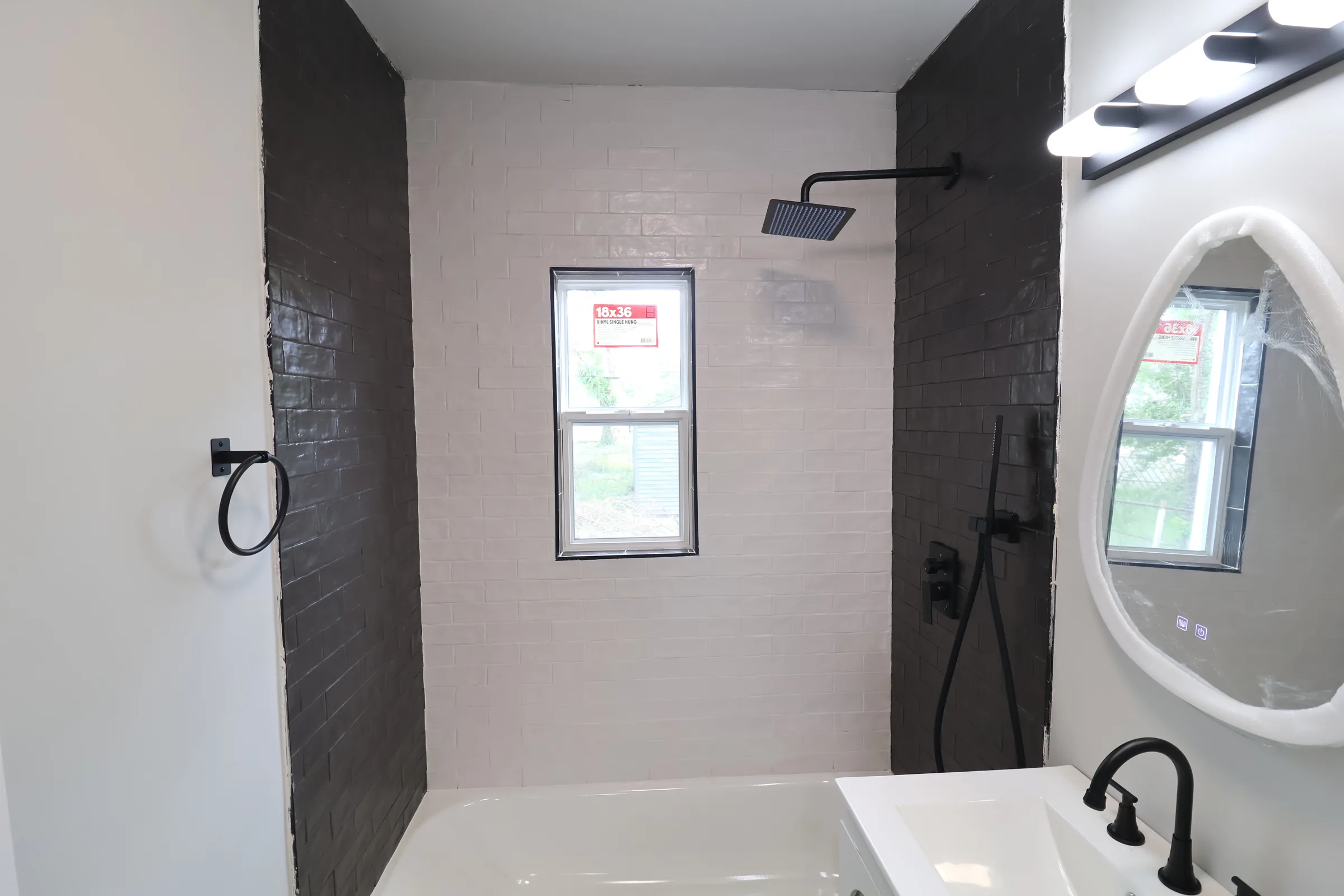 Finished bathroom with black and white tile