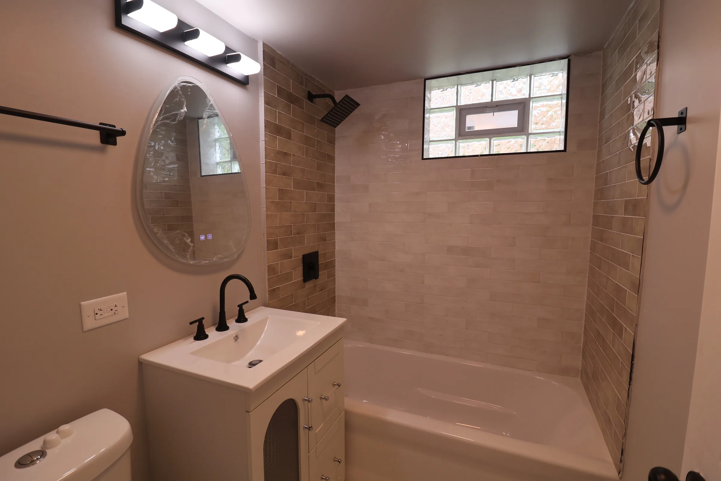 Finished bathroom with warm tile and vanity